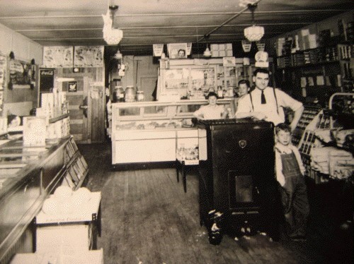 Inside Becco's Market in 1939, with Frank Becco behind the counter and young Tom beside the stove